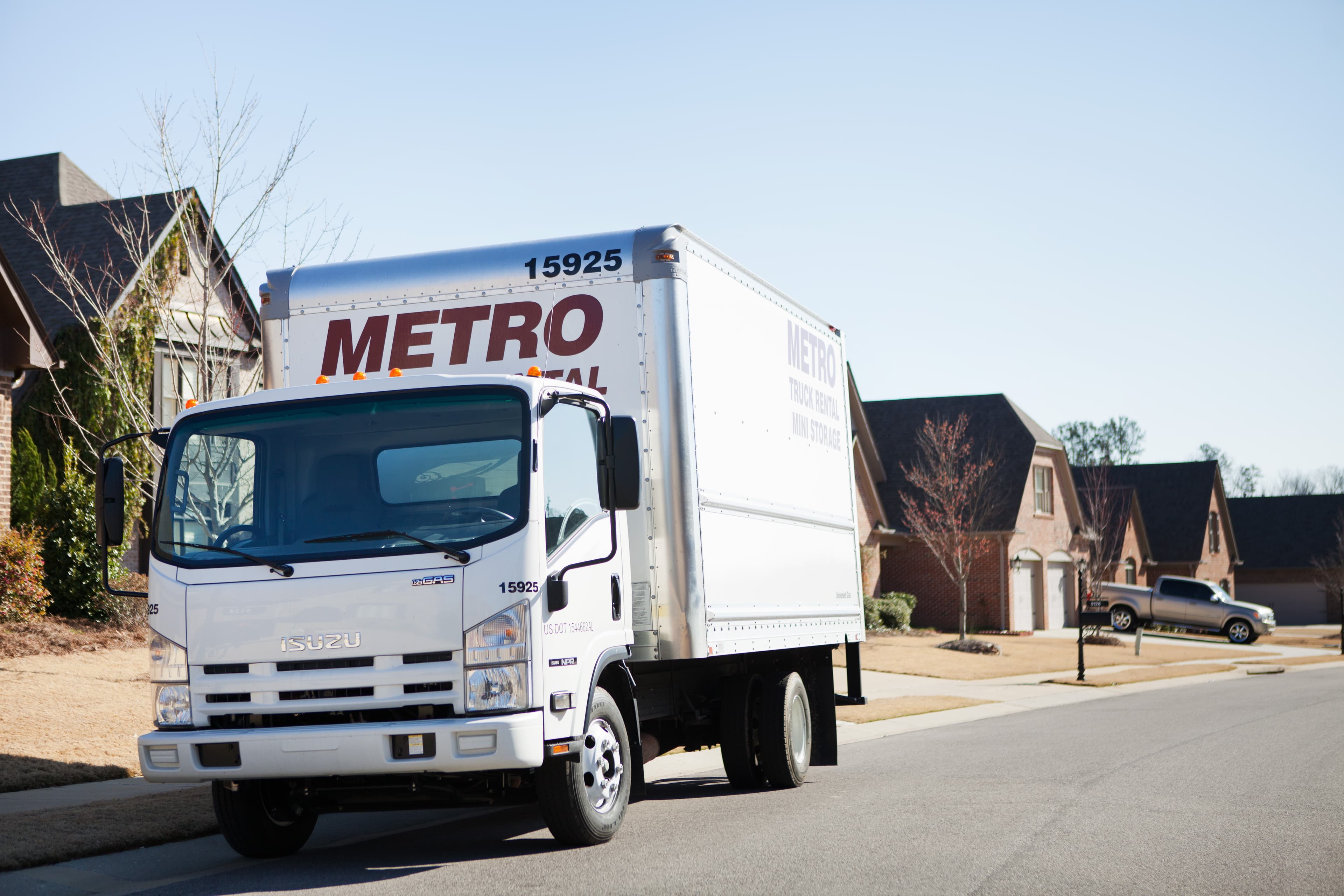 Metro box truck parked curbside during a delivery stop.