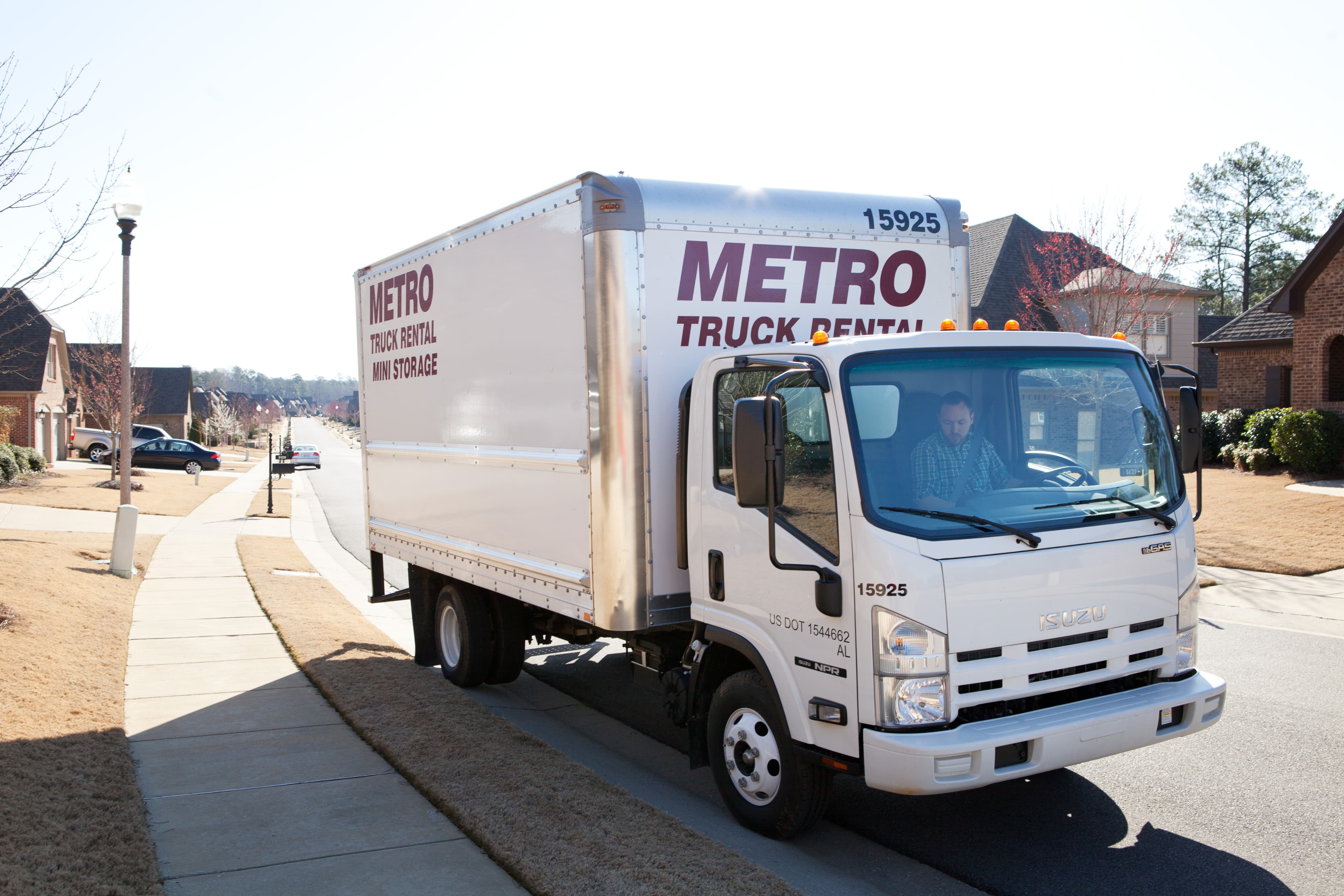 Metro truck parked curbside in a suburban area.